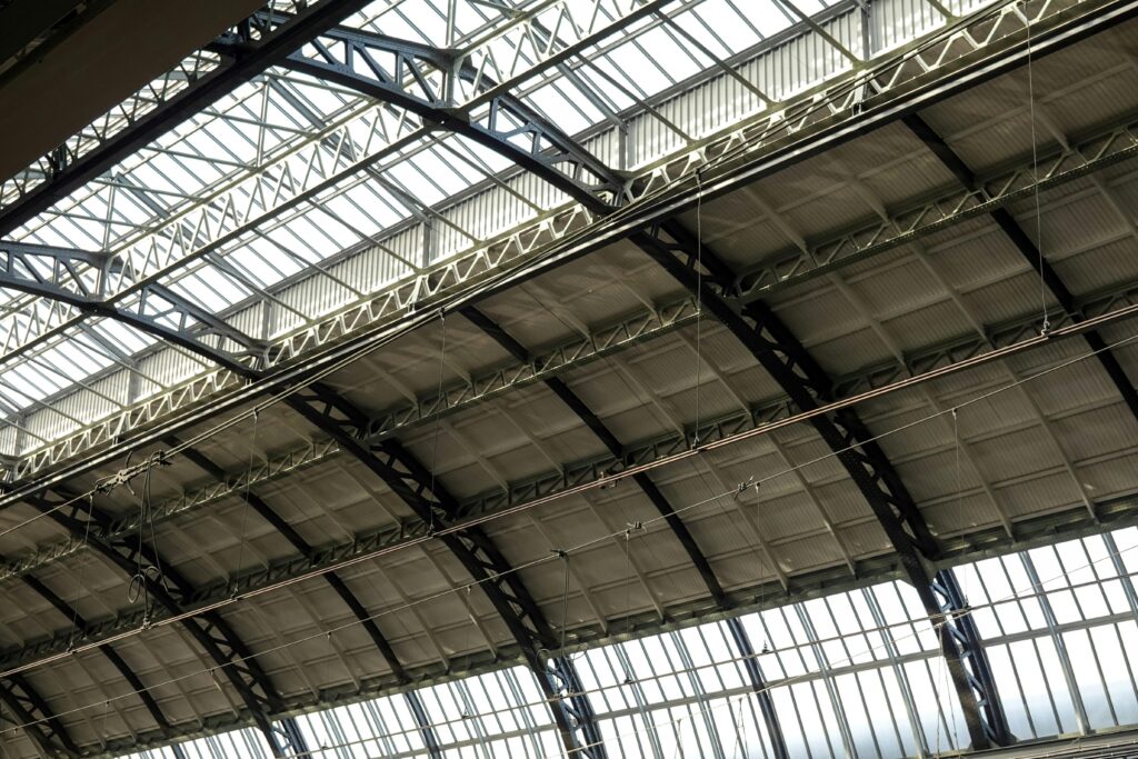 Intricate steel and glass ceiling design of an urban train station.